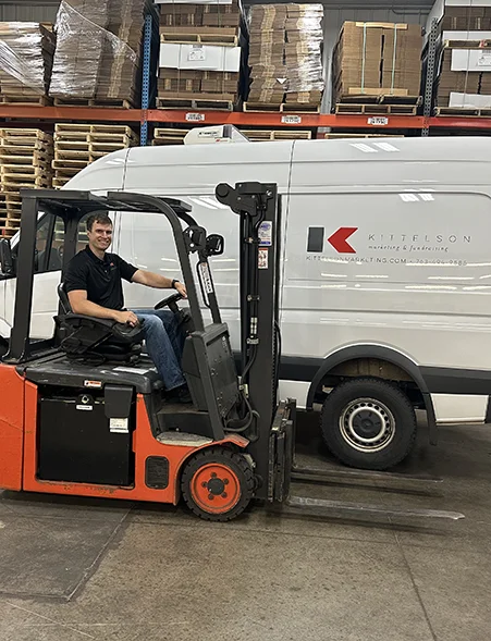 Kittelson team member on a forklift next to a delivery van